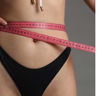 Tape measure wrapped around a woman’s waist