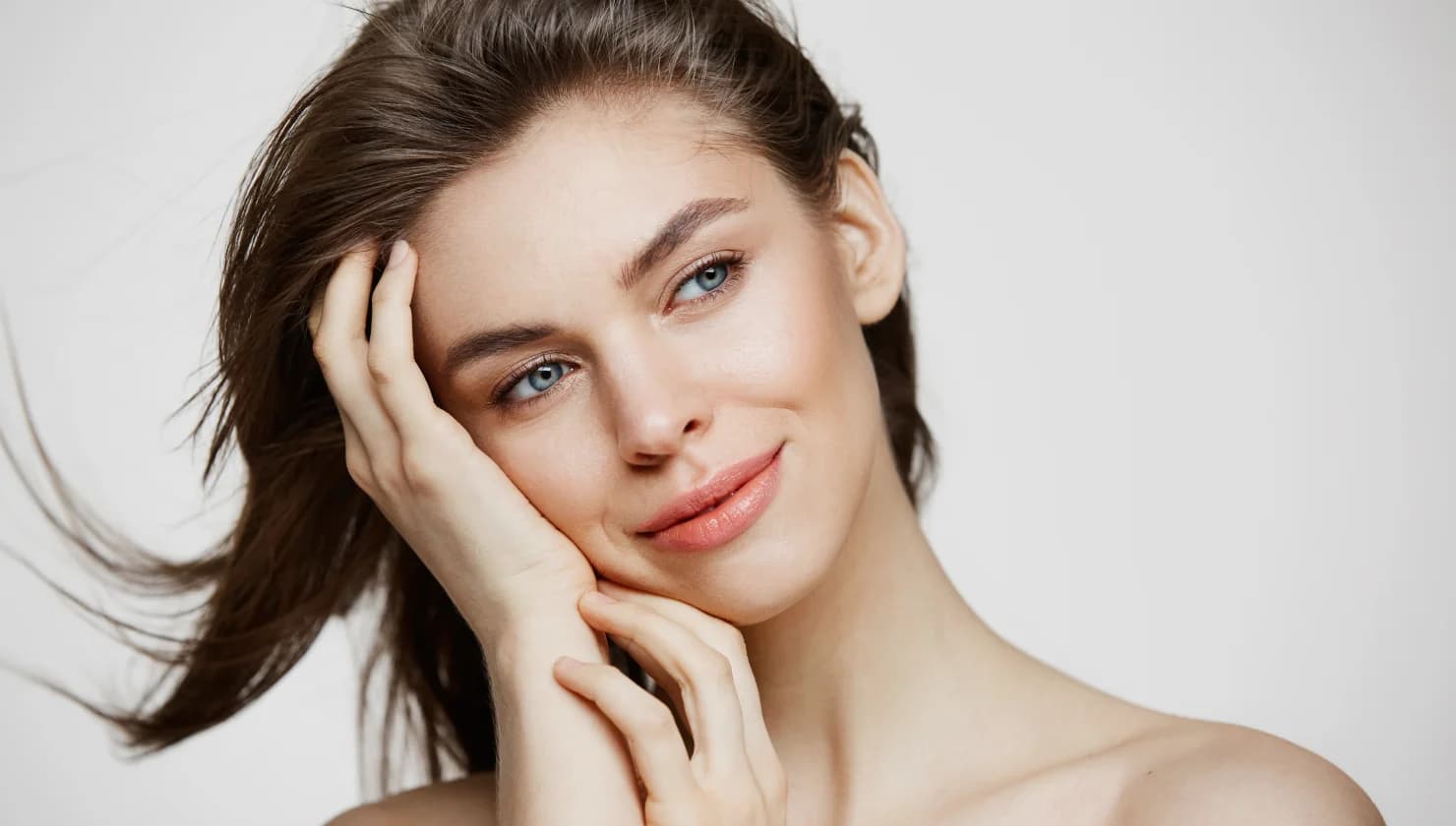 Woman resting her hand along a defined jawline