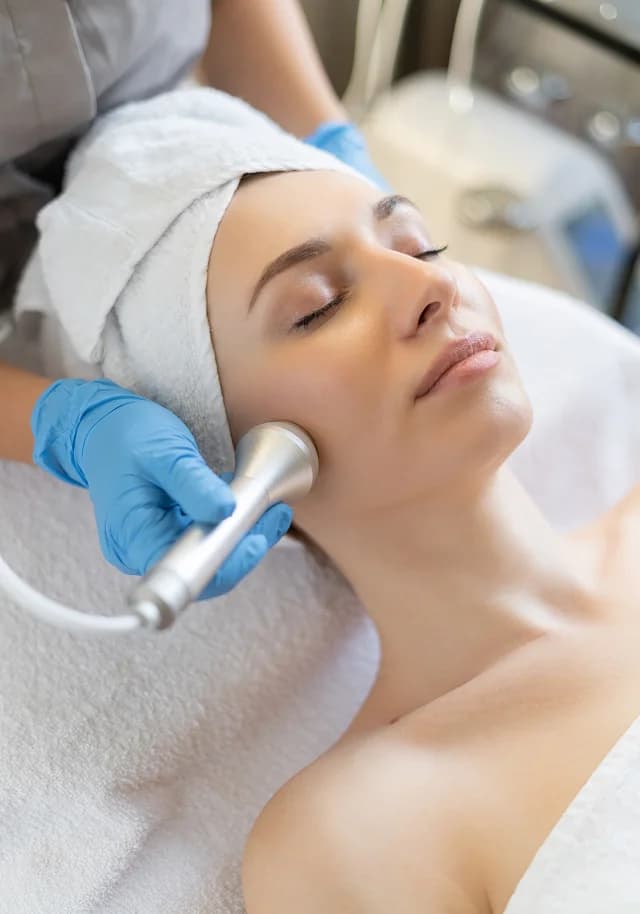 Laser handpiece passing over the cheek during a skin resurfacing treatment